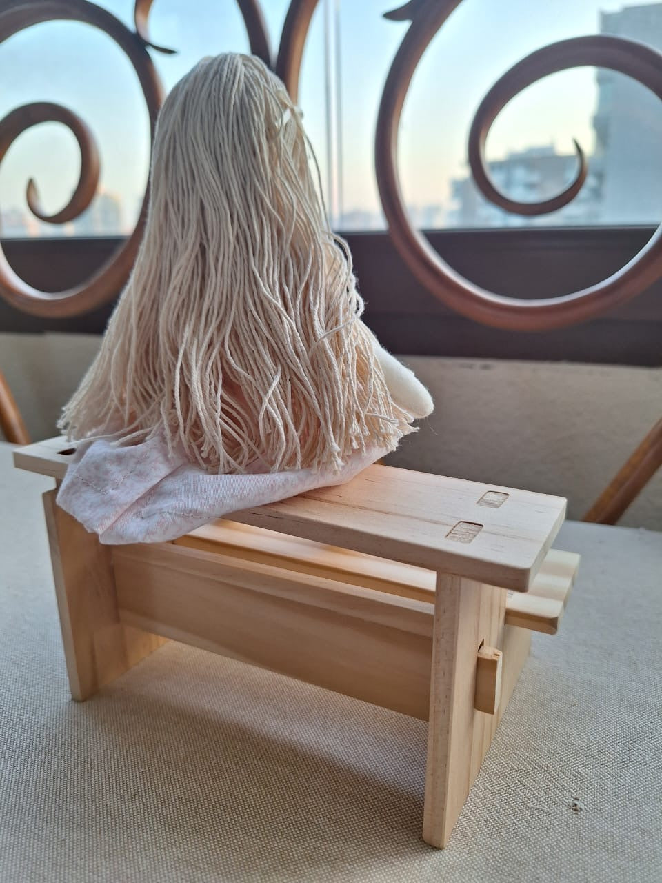 Muñeca en banco de madera